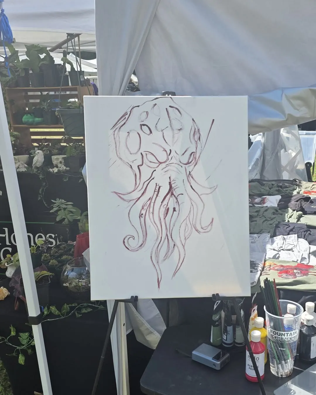 Blank canvas on an easel with a red line sketch of Cthulhu