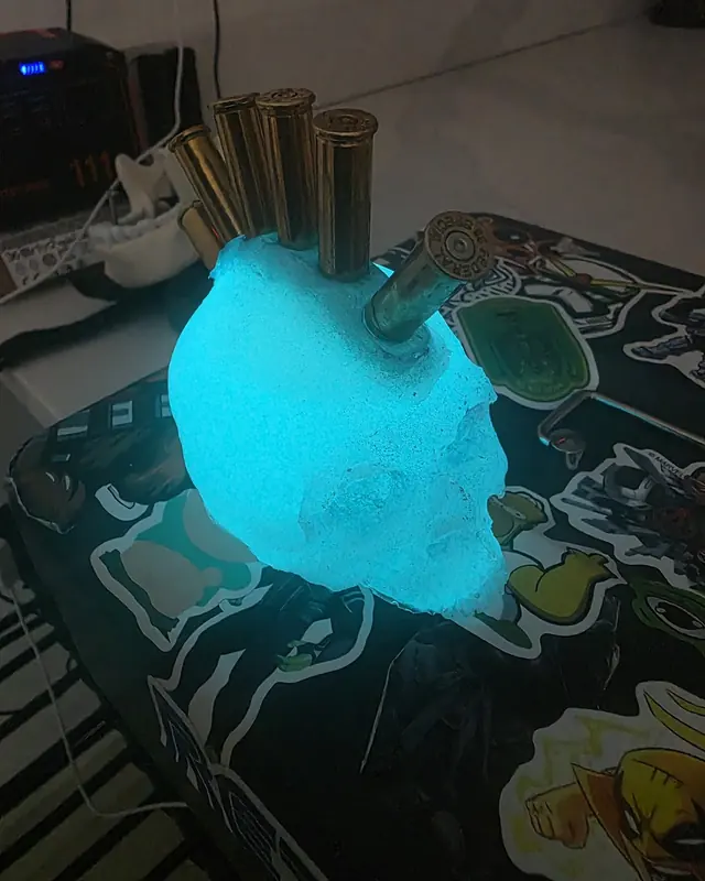 Resin skull glowing ice blue with brass shell casings set in the top