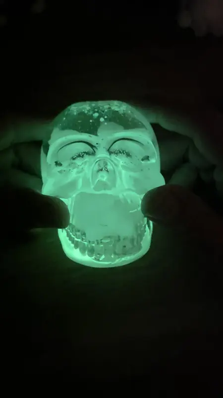 Clear resin skull glowing bright green in the dark