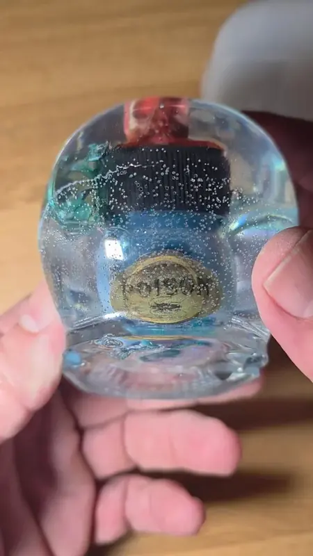Clear resin skull with a red-capped vial inside, fresh from the mold